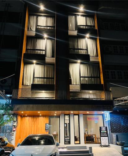 a building with a car parked in front of it at Woodstory Boutique Hotel in Bangkok