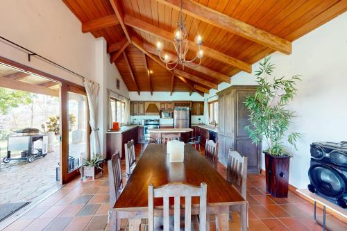 an open kitchen with a wooden table and chairs at Finca de La Luna in Atenas