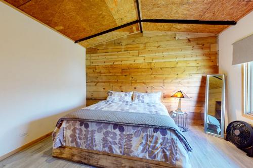 uma cama num quarto com uma parede de madeira em Finca de La Luna em Atenas