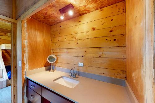 baño con lavabo y pared de madera en Finca de La Luna, en Atenas