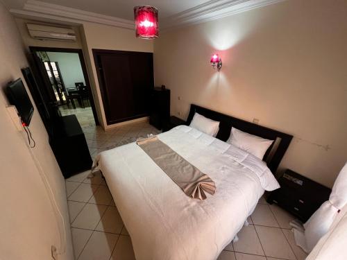 1 dormitorio con 1 cama grande con sábanas y almohadas blancas en Magnifique, Appartement, familial, spacieux 2chambres salon salle à manger en Marrakech