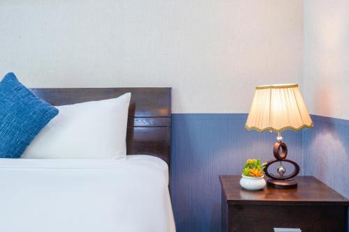 a bedroom with a bed and a table with a lamp at La Serena Boutique Hotel in Ho Chi Minh City
