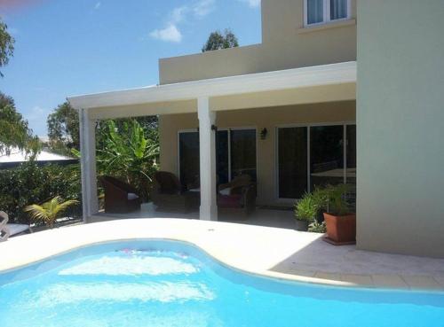 a swimming pool in front of a house at Black River Villa Turquoise 3bdr, sea view in Rivière Noire