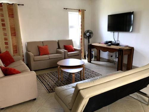 a living room with a couch and a table at Black River Villa Turquoise 3bdr, sea view in Rivière Noire