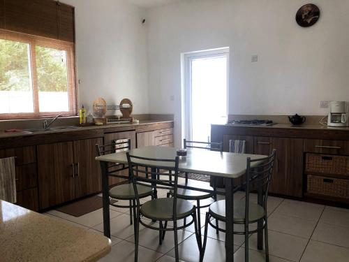 a kitchen with a table and some chairs in it at Black River Villa Turquoise 3bdr, sea view in Rivière Noire