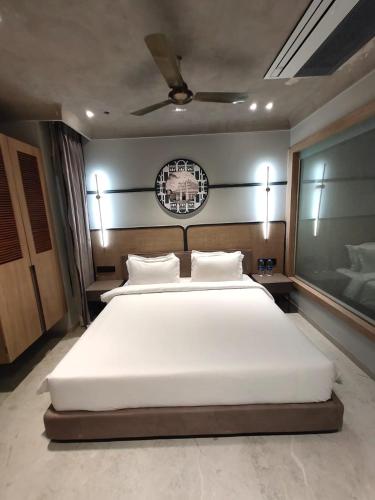 a bedroom with a large bed with white sheets at Playotel Inn Aria, Bhopal in Bhopal