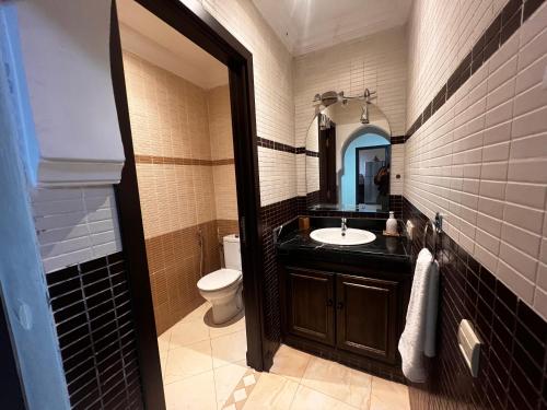 a bathroom with a sink and a toilet and a mirror at Magnifique, Appartement, familial, spacieux 2chambres salon salle à manger in Marrakesh