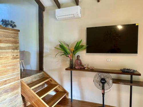 sala de estar con TV de pantalla plana en la pared en TukoKubo en El Nido