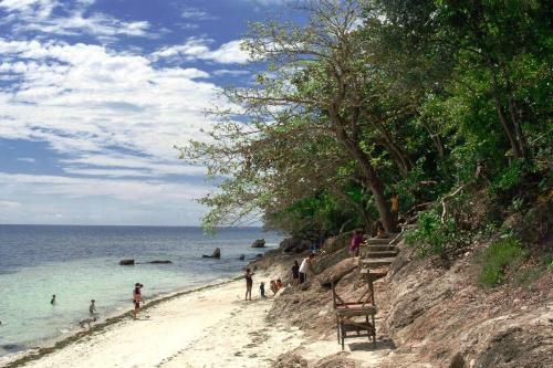 a group of people on a sandy beach near the ocean at Villa Izabella in Panglao Island in Dauis