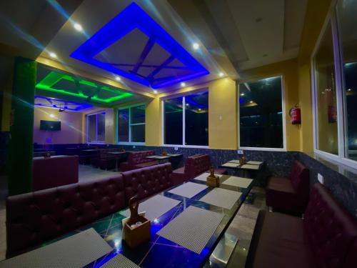 um restaurante com sofás e mesas e luzes azuis em Motel on Mountain & Mom ki Rasoi em Srīnagar