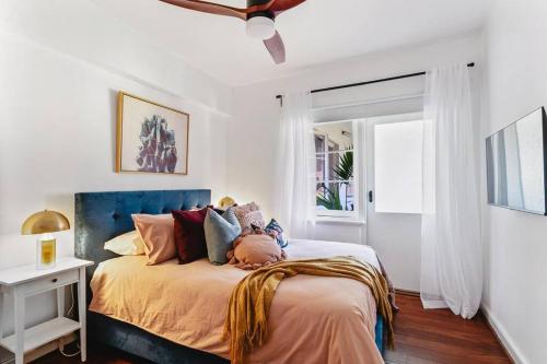 1 dormitorio con 1 cama con cabecero azul en Vintage 2BR CBD Apartment w/River View en Perth