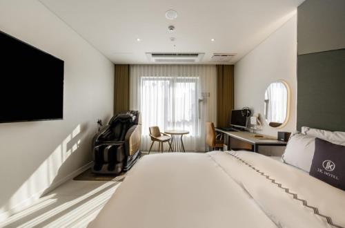 ein Hotelzimmer mit einem Bett und einem Schreibtisch in der Unterkunft Gimpo JK Hotel in Gimpo