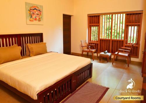 1 dormitorio con 1 cama grande en una habitación en Back to Roots Ayurveda Retreat, en Kizhake Chālakudi