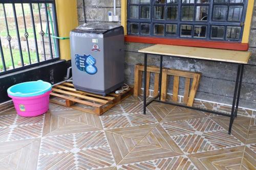 a trash can sitting on a floor next to a table at Esniko Villa in Narok