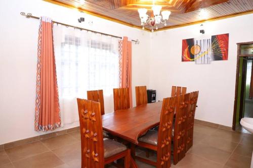 a dining room with a wooden table and chairs at Esniko Villa in Narok