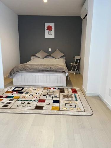 a bedroom with a bed and a rug on the floor at 福偉亭 in Otaru