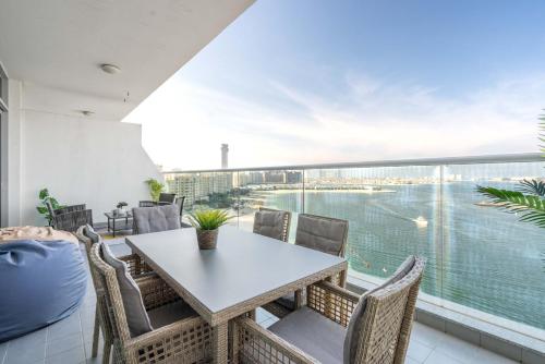 a dining room with a table and chairs and a large window at GuestReady - Glamourous living in Palm Jumeirah in Dubai