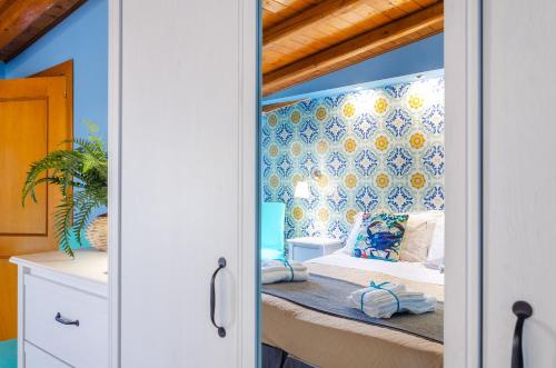 a bedroom with a bed with blue walls at Casa delle Zammare Fronte mare centro storico in Riposto