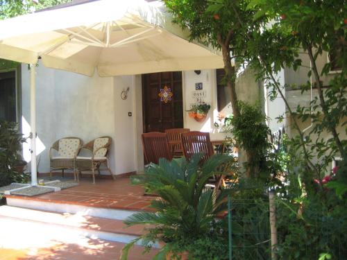 een patio met stoelen en een parasol op een huis bij B&B Oasi di Venezia in Campalto