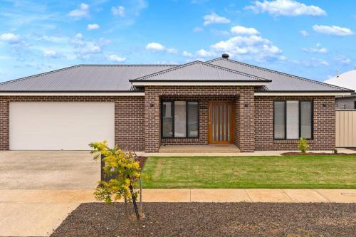 a red brick house with a white garage at Popular Luxury Villa Kialla Shepparton in Kialla