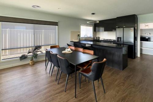 a kitchen and dining room with a table and chairs at Popular Luxury Villa Kialla Shepparton in Kialla
