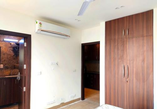 a room with a hallway with wooden cabinets and a heater at When In Gurgaon - ARTEMIS HOSPITAL 1 Min Walk, FORTIS & MEDANTA 4 Mins Drive in Gurgaon