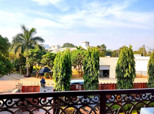 a balcony with trees and a person on a motorcycle at When In Gurgaon - ARTEMIS HOSPITAL 1 Min Walk, FORTIS & MEDANTA 4 Mins Drive in Gurgaon