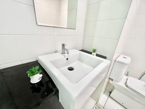 a white bathroom with a sink and a toilet at K 1-5Pax Trefoil Cozy Home Setia Alam TV Wifi SCCC in Shah Alam