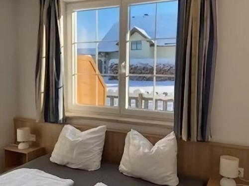 ein Bett mit Kissen und ein Fenster mit Aussicht in der Unterkunft Apartment in Sankt Margarethen near ski area in Sankt Margarethen im Lungau