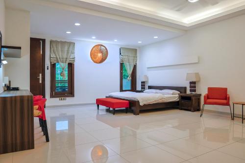 1 dormitorio con 1 cama y 2 sillas rojas en Kuah Town - Villa Indah, en Kuah