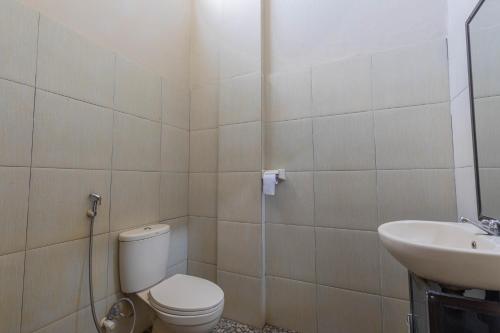 a bathroom with a toilet and a sink at Jepun Guest House in Mataram