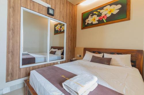 a bedroom with a large bed and a mirror at Jepun Guest House in Mataram