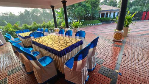 a table with blue chairs on a brick patio at GB 25 Cottage in Trivandrum