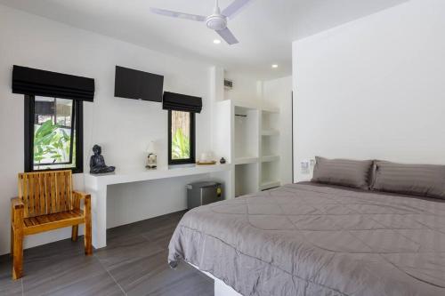 - une chambre avec un lit, une chaise et des fenêtres dans l'établissement Surya Villa, à Ko Pha Ngan