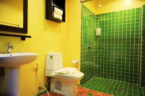 a bathroom with a green tiled shower and a toilet at Harmony Patong Hotel in Patong Beach