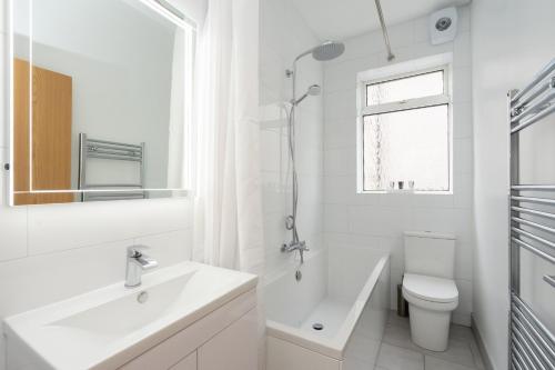 een witte badkamer met een wastafel en een toilet bij Beautiful 2 Bedroom Flat on Street Lane in Moortown