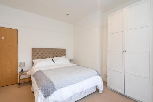 a white bedroom with a bed and a closet at Beautiful 2 Bedroom Flat on Street Lane in Moortown