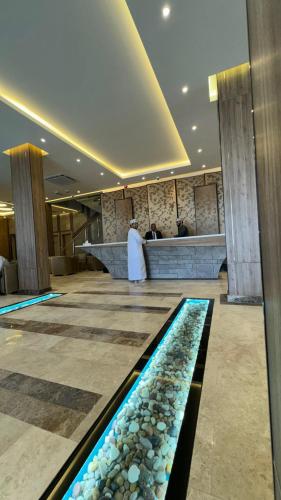 a woman standing in a lobby with a pool of water at Royal Plaza Hotel in Duqm