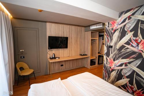 a bedroom with a bed and a tv on a wall at Cosmopolita Boutique Hotel in Timişoara