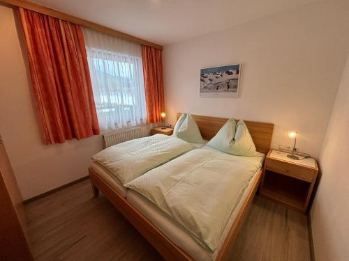 een slaapkamer met een bed en een raam bij Ferienwohnungen Passrugger in Eben im Pongau