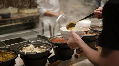a person is preparing food in a kitchen at The Westin Ningbo in Ningbo