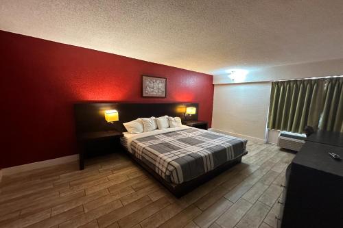 a bedroom with a bed with a red wall at River Valley Inn and Suites I-40 in Fort Smith