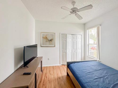 een slaapkamer met een bed en een plafondventilator bij Grand Exclusive 4BR Pool Home near Disney Parks in Davenport