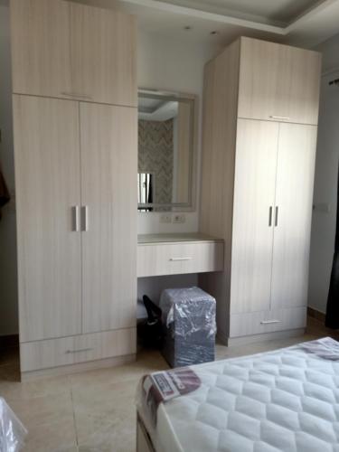 a bedroom with white cabinets and a bed and a mirror at Fully furnished - 80 mt in Celia compound in new administrative city in Cairo