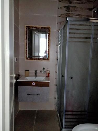 a bathroom with a sink and a shower with a mirror at Fully furnished - 80 mt in Celia compound in new administrative city in Cairo