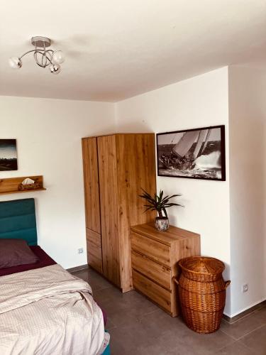 a bedroom with a bed and a wooden cabinet at Pokoj v rodinném domě Severní in České Budějovice