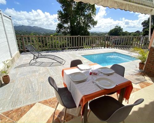 a table and chairs sitting next to a swimming pool at Appartement T2 - vue campagne in Le Robert