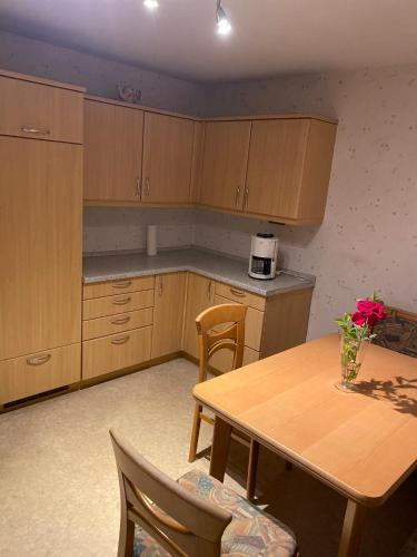 eine Küche mit einem Holztisch sowie einem Tisch und Stühlen in der Unterkunft Monteur Wohnung Unterkunft in Hohberg