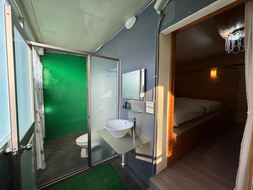 a small bathroom with a toilet and a sink at Runners' House Taitung in Changbin