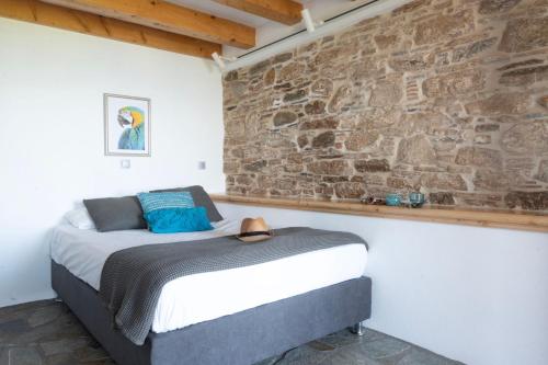 a bed in a room with a stone wall at Kleine Villa mit Meerblick, Samos, Griechenland in Samos